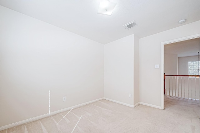 spare room with light carpet, visible vents, and baseboards