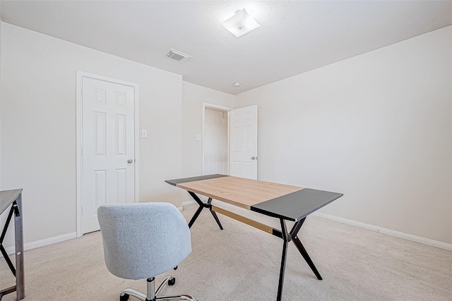 office with baseboards, visible vents, and light colored carpet