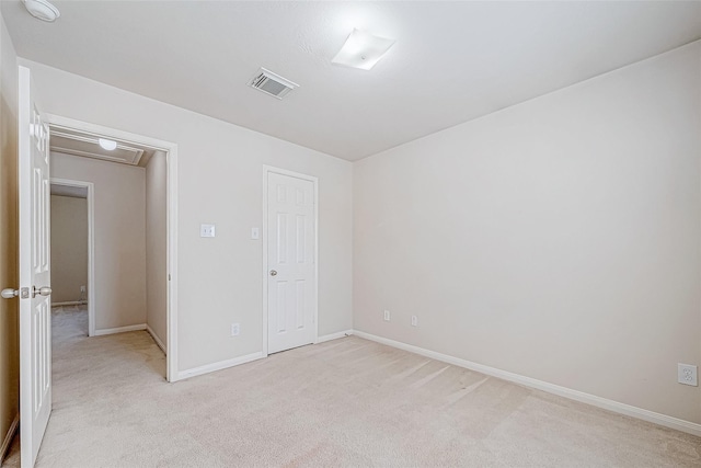 unfurnished room featuring baseboards, visible vents, and light colored carpet