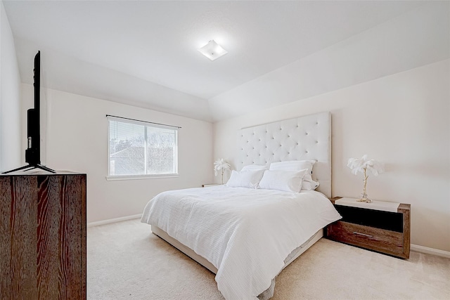 bedroom featuring lofted ceiling, baseboards, and light colored carpet