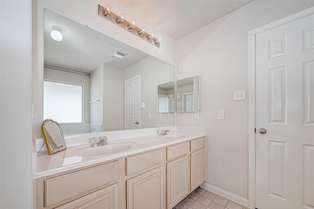 bathroom featuring visible vents, a sink, baseboards, and double vanity