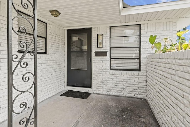 doorway to property with brick siding