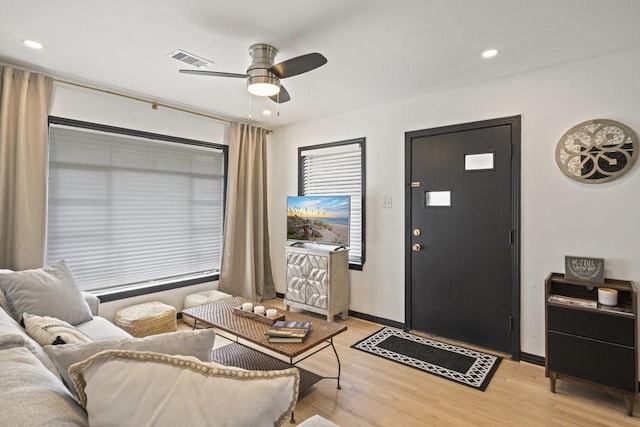 living room with baseboards, visible vents, a ceiling fan, light wood-style floors, and recessed lighting