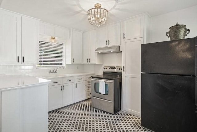 kitchen featuring electric stove, light countertops, freestanding refrigerator, white cabinets, and under cabinet range hood