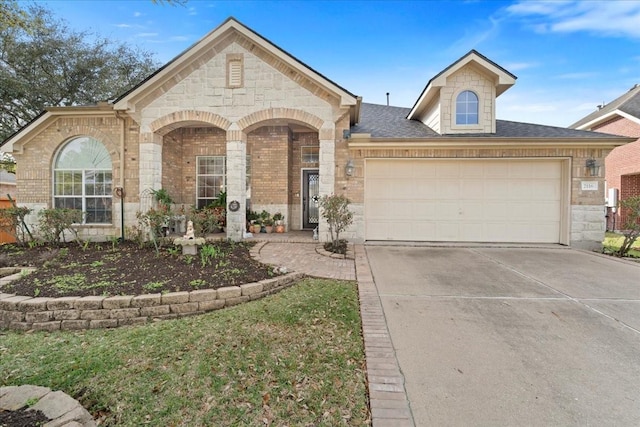 view of front of house with concrete driveway, brick siding, an attached garage, and stone siding