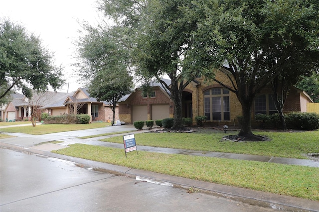 view of front of property featuring concrete driveway, brick siding, an attached garage, and a front lawn