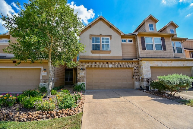 view of property with brick siding, stucco siding, a garage, stone siding, and driveway