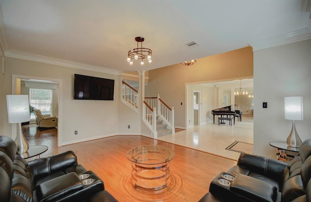 living room featuring visible vents, stairway, an inviting chandelier, ornamental molding, and wood finished floors