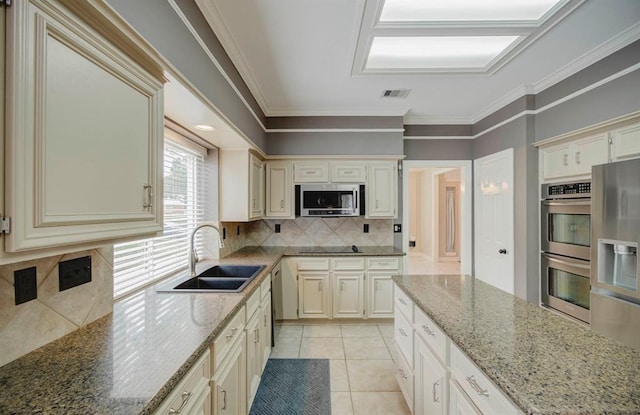 kitchen featuring stainless steel appliances, visible vents, a sink, and cream cabinets