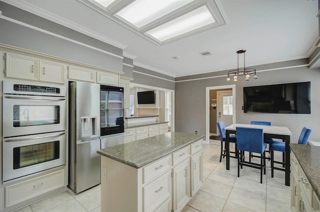 kitchen featuring stone counters, crown molding, light tile patterned floors, visible vents, and appliances with stainless steel finishes