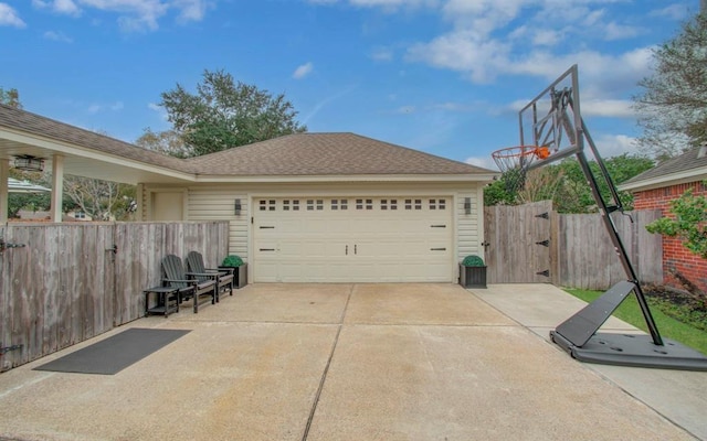 exterior space featuring a garage, fence, driveway, and a shingled roof