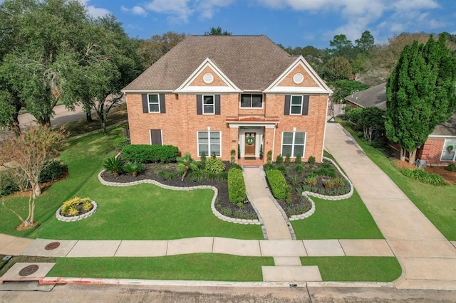 view of front of property with driveway, brick siding, and a front yard