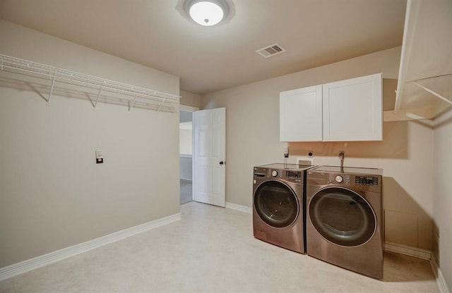 laundry room with baseboards, visible vents, cabinet space, and washing machine and clothes dryer