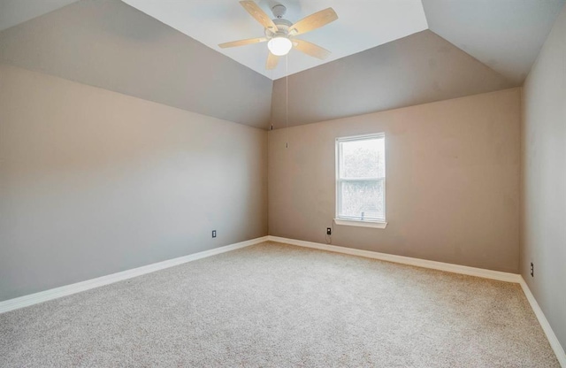 empty room with lofted ceiling, baseboards, and carpet