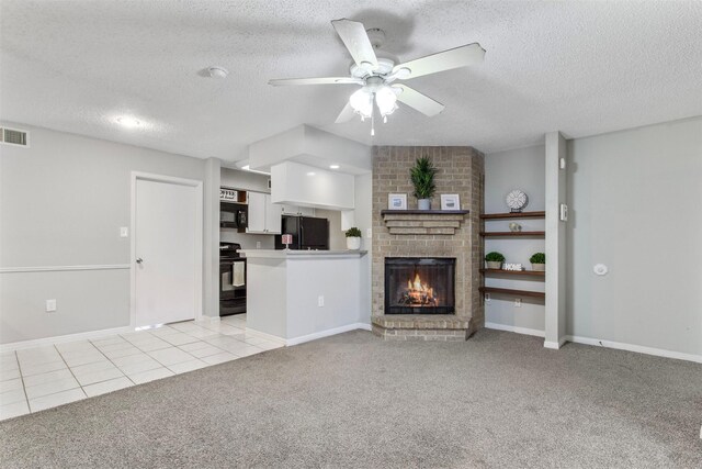 250 El Dorado Blvd Unit 203, Webster, TX 77598 - unfurnished living room with light carpet, ceiling fan, a textured ceiling, a fireplace, and light tile patterned floors