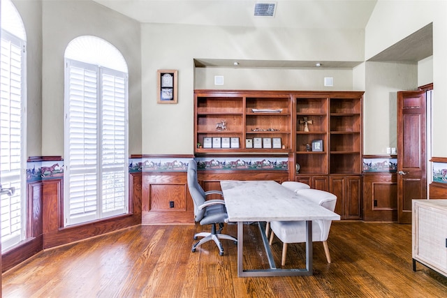 office area featuring a wainscoted wall, plenty of natural light, dark wood-style floors, and visible vents