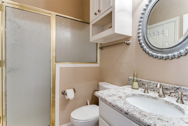 full bathroom with a stall shower, vanity, and toilet