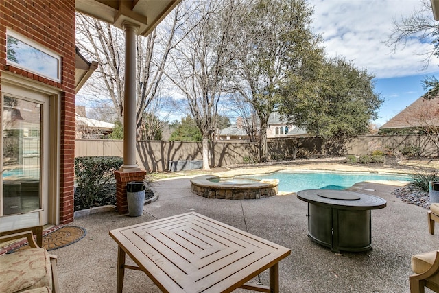 view of pool with a fenced backyard, a pool with connected hot tub, and a patio