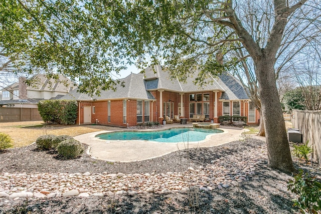 view of swimming pool with a patio area, a fenced backyard, and a pool with connected hot tub