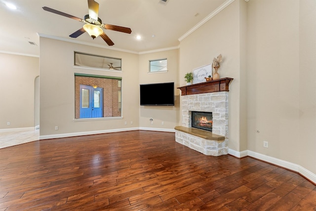 unfurnished living room featuring ornamental molding, baseboards, and wood finished floors