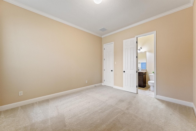 empty room featuring ornamental molding, light colored carpet, and baseboards