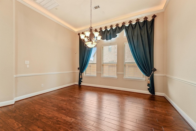 spare room featuring a notable chandelier, dark wood-style flooring, visible vents, baseboards, and crown molding