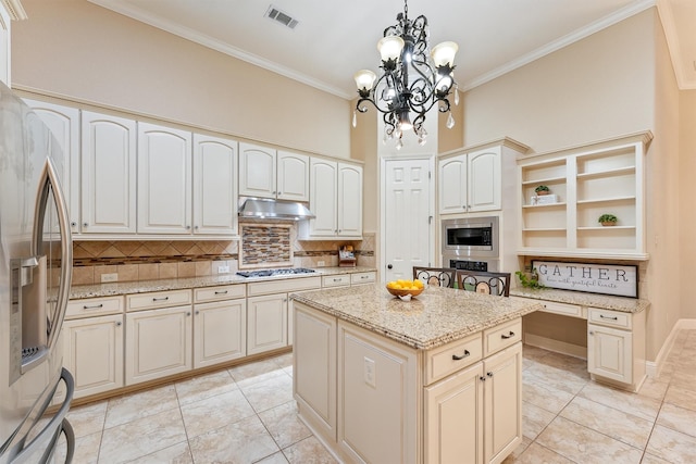 kitchen featuring a center island, pendant lighting, stainless steel appliances, visible vents, and under cabinet range hood