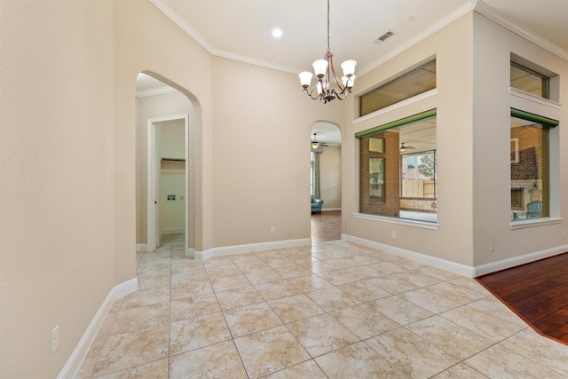 interior space with baseboards, visible vents, arched walkways, and ornamental molding