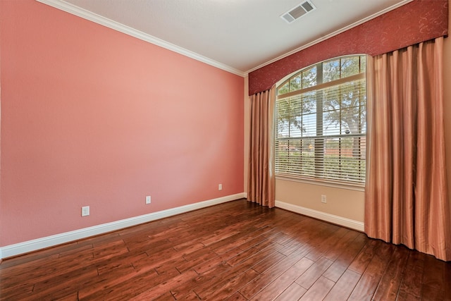 unfurnished room with dark wood-style floors, visible vents, a wealth of natural light, and ornamental molding