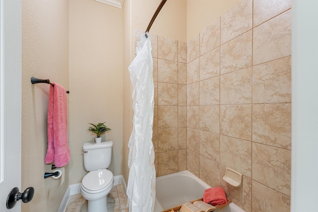 bathroom with tile patterned floors, shower / bath combo with shower curtain, toilet, and baseboards