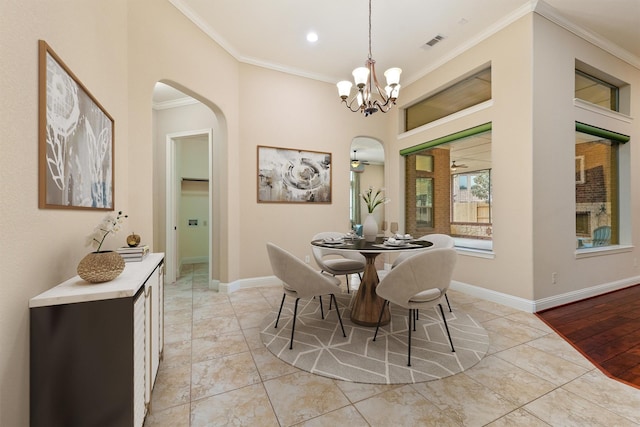 dining room with arched walkways, light tile patterned floors, visible vents, baseboards, and ornamental molding