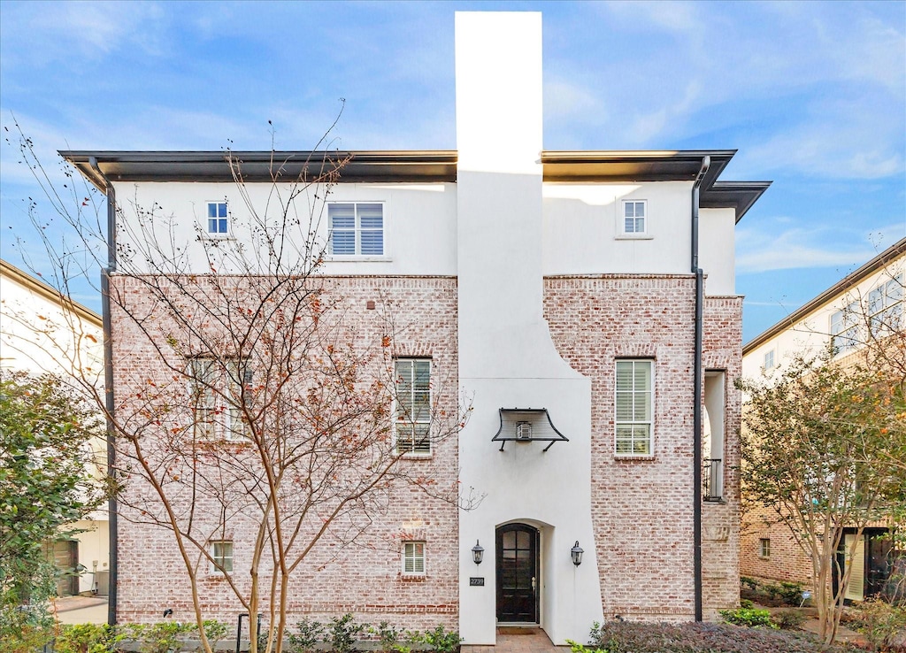 view of front of property with brick siding and stucco siding