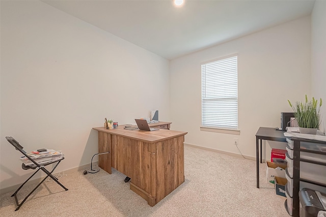 office with baseboards and light colored carpet