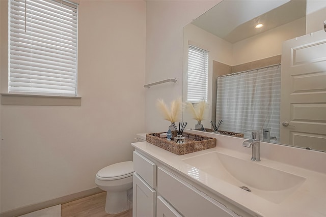 full bathroom featuring toilet, vanity, wood finished floors, a shower with curtain, and baseboards