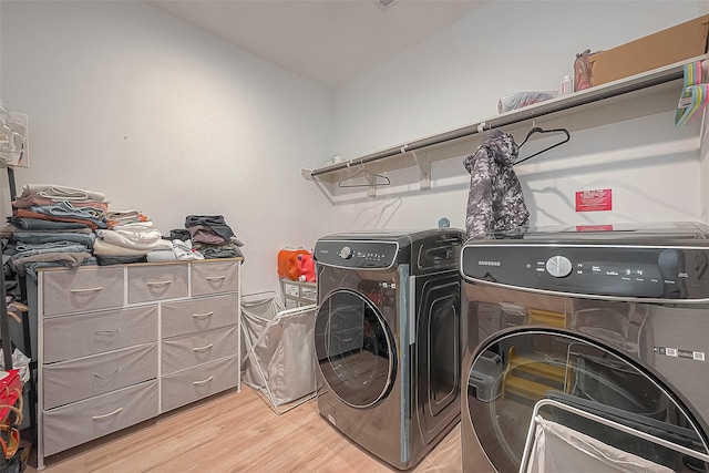 laundry room with laundry area, light wood finished floors, and washer and dryer