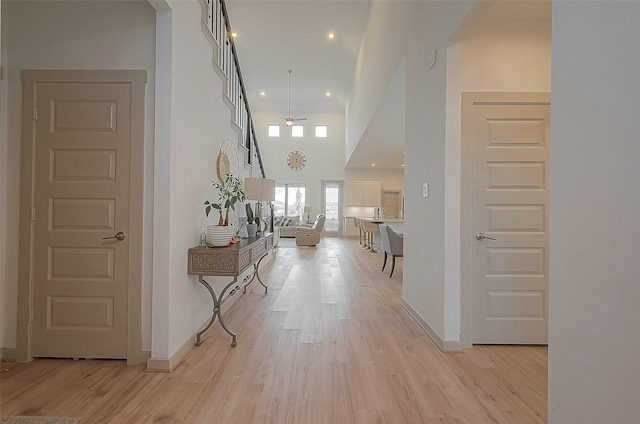 corridor featuring light wood-style flooring and baseboards