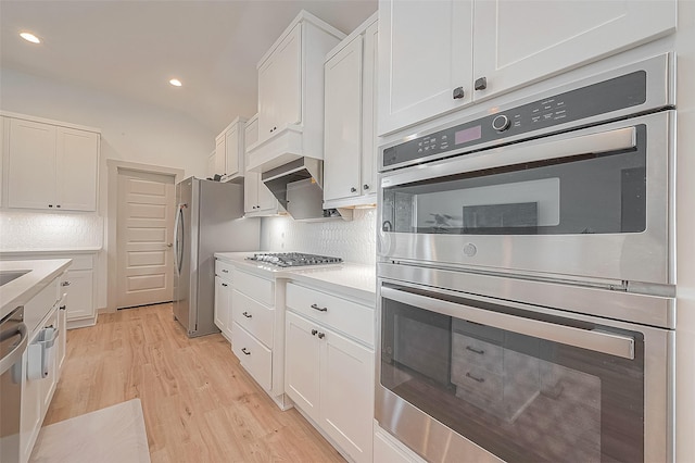 kitchen with stainless steel appliances, white cabinets, light countertops, and light wood finished floors