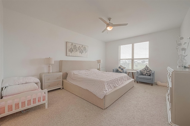 bedroom with light carpet and a ceiling fan