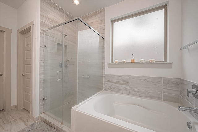 bathroom featuring marble finish floor, a stall shower, a garden tub, and recessed lighting