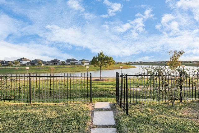 view of yard featuring a water view, a residential view, and fence