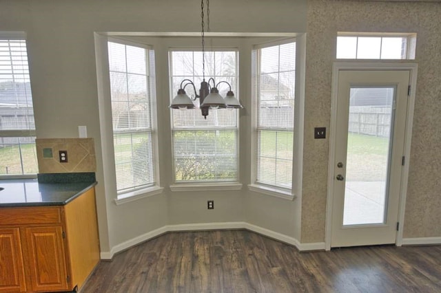 57 Sunrose Ct, Lake Jackson, TX 77566 - unfurnished dining area with baseboards, dark wood-style flooring, and an inviting chandelier