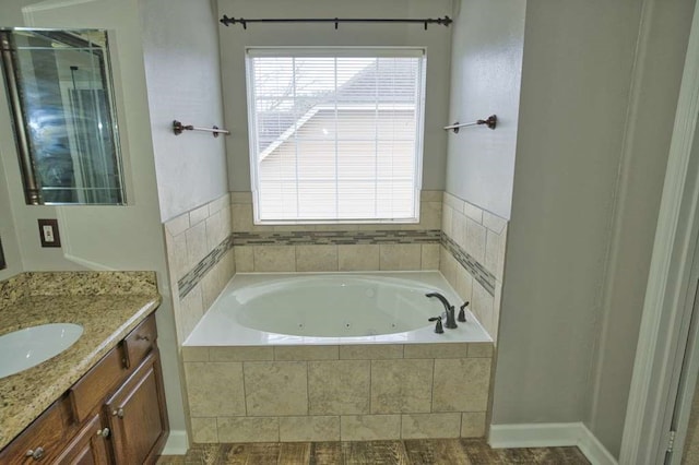 57 Sunrose Ct, Lake Jackson, TX 77566 - bathroom featuring a jetted tub, vanity, and a healthy amount of sunlight