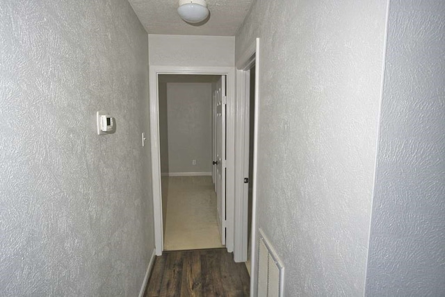 57 Sunrose Ct, Lake Jackson, TX 77566 - corridor featuring a textured wall, dark wood finished floors, and visible vents