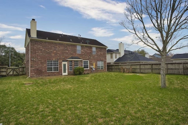 57 Sunrose Ct, Lake Jackson, TX 77566 - back of property with a fenced backyard, a chimney, a lawn, and brick siding