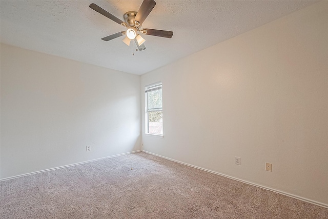 carpeted spare room featuring a textured ceiling, ceiling fan, and baseboards