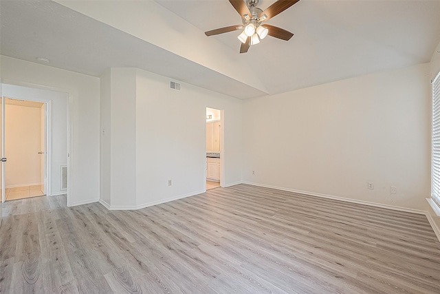 empty room featuring baseboards, ceiling fan, vaulted ceiling, and light wood-style floors