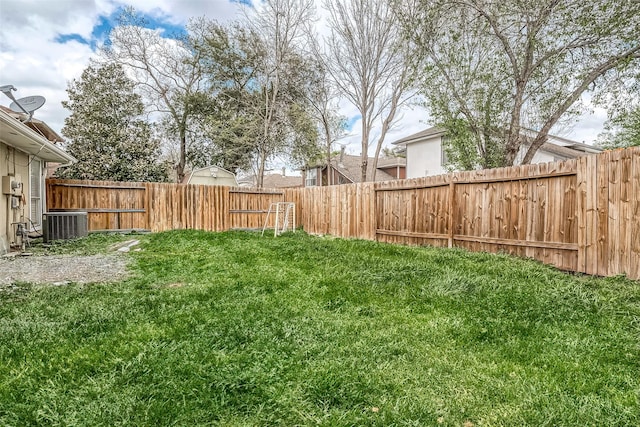 view of yard featuring central AC and a fenced backyard