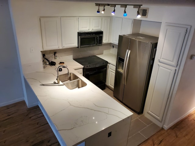 kitchen featuring stainless steel appliances, a peninsula, a sink, and white cabinets