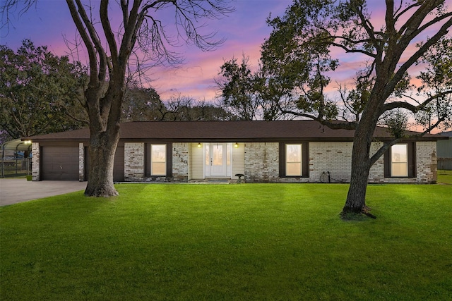 view of front of home with a garage, concrete driveway, brick siding, and a front lawn