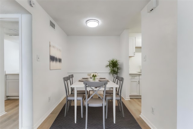 dining room featuring light wood-style floors, baseboards, and visible vents